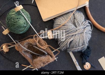 Chaotisch kreatives Chaos auf dem Tisch beim Stricken von Socken Stockfoto