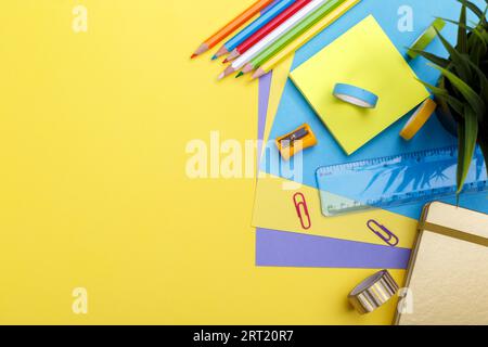 Wieder-in-die-Schule-Konzept. Farbenfrohes Büromaterial für die Schule auf gelbem Hintergrund, Platz- oder Textunterlage Stockfoto