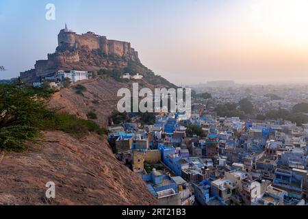 Jodhpur, Indien, 10. Dezember 2019: Blick auf die Stadt bei Sonnenaufgang mit blauen Häusern und Mehrangarh Fort im Hintergrund Stockfoto