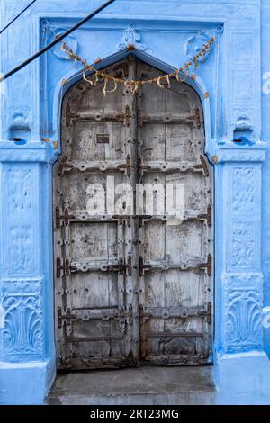 Jodhpur, Indien, 9. Dezember 2019: Ein altes Tor zu einem traditionellen blauen Haus Stockfoto