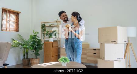 Verheiratete indische Ehepaare, die ein Hausmodell in einem neuen Zuhause halten. Umzugskonzept Stockfoto