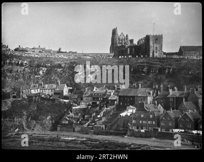 Whitby, Scarborough, North Yorkshire, 1925-1935. Ein Blick von der West Cliff in Whitby auf die Häuser in der Henrietta Street mit Whitby Abbey und St. Mary's Church auf der Klippe oben. Stockfoto