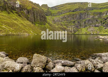 Coumshingaun Lough mit Felsen und Vegetation, Waterford, Irland Stockfoto