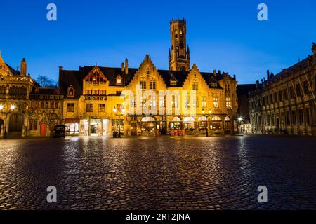 BRÜGGE, BELGIEN - 19. FEBRUAR 2016: Gebäude auf dem Burgplatz in Brügge bei Sonnenuntergang mit blauem Himmel. Der Belfried von Brügge ist in der Ferne zu sehen. Stockfoto