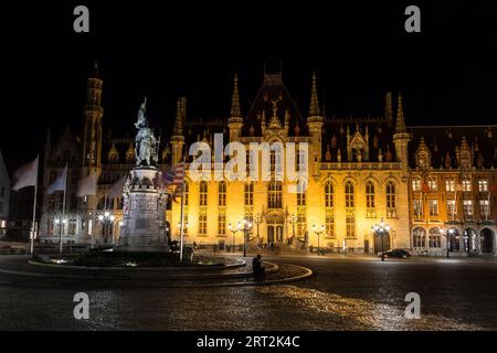 BRÜGGE, BELGIEN- 19. FEBRUAR 2016: Das Äußere des Provinciaal Hofes am Grote Markt in Brügge bei Nacht. Es gibt eine Statue von Jan Stockfoto