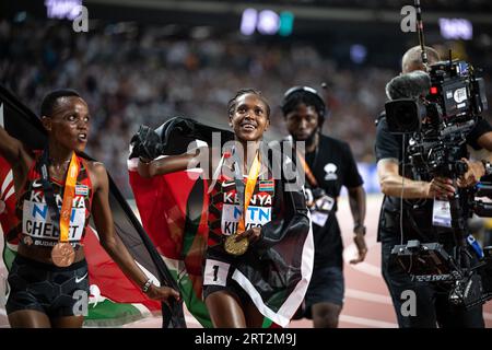 Faith Kipyegon und Beatrice Chebet feiern bei den Leichtathletik-Weltmeisterschaften in Budapest die Hermedal mit der Flagge ihres Landes auf den 5000 Metern Stockfoto