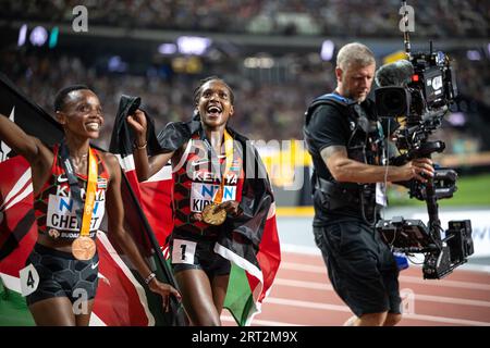 Faith Kipyegon und Beatrice Chebet feiern bei den Leichtathletik-Weltmeisterschaften in Budapest die Hermedal mit der Flagge ihres Landes auf den 5000 Metern Stockfoto