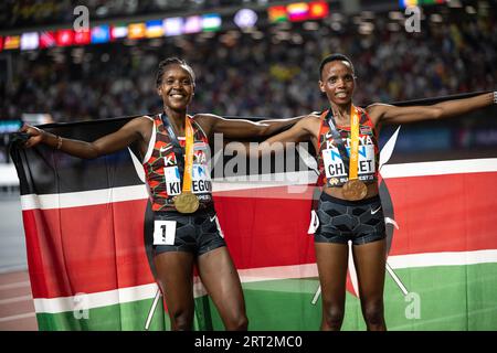 Faith Kipyegon und Beatrice Chebet feiern bei den Leichtathletik-Weltmeisterschaften in Budapest die Hermedal mit der Flagge ihres Landes auf den 5000 Metern Stockfoto