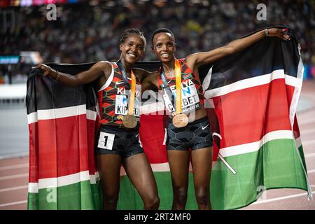 Faith Kipyegon und Beatrice Chebet feiern bei den Leichtathletik-Weltmeisterschaften in Budapest die Hermedal mit der Flagge ihres Landes auf den 5000 Metern Stockfoto