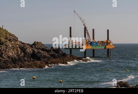 Polperro, Cornwall, England, Großbritannien. September 2023. Abhilfemaßnahmen, die von einer Aufbockplattform im Meer aus durchgeführt werden, um einen Außenposten mit Beton zu bedecken Stockfoto