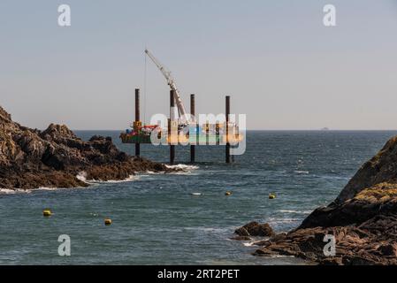 Polperro, Cornwall, England, Großbritannien. September 2023. Abhilfemaßnahmen, die von einer Aufbockplattform im Meer aus durchgeführt werden, um einen Außenposten mit Beton zu bedecken Stockfoto