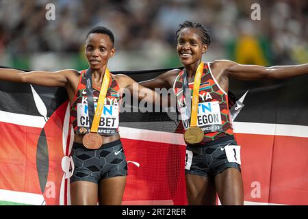 Faith Kipyegon und Beatrice Chebet feiern bei den Leichtathletik-Weltmeisterschaften in Budapest die Hermedal mit der Flagge ihres Landes auf den 5000 Metern Stockfoto