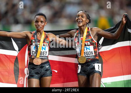 Faith Kipyegon und Beatrice Chebet feiern bei den Leichtathletik-Weltmeisterschaften in Budapest die Hermedal mit der Flagge ihres Landes auf den 5000 Metern Stockfoto