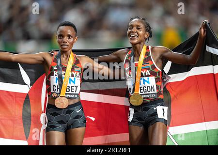 Faith Kipyegon und Beatrice Chebet feiern bei den Leichtathletik-Weltmeisterschaften in Budapest die Hermedal mit der Flagge ihres Landes auf den 5000 Metern Stockfoto