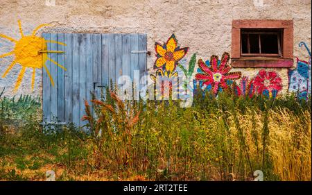 Kinderbilder an einer alten Hauswand Stockfoto