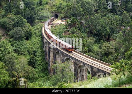 Demodara, Sri Lanka, 4. August 2018: Ein roter Zug, der die berühmte Nine Arch Bridge überquert Stockfoto