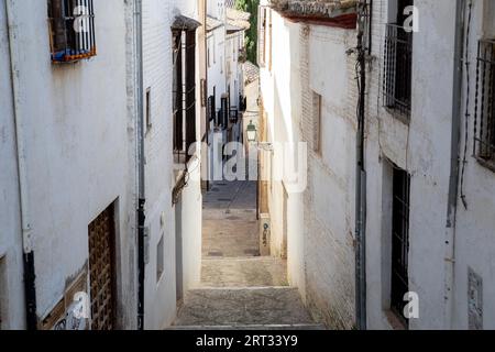 Granada, Spanien, 27. Mai 2019: Eine enge Gasse mit weißen Häusern im historischen Bezirk Albaicin Stockfoto