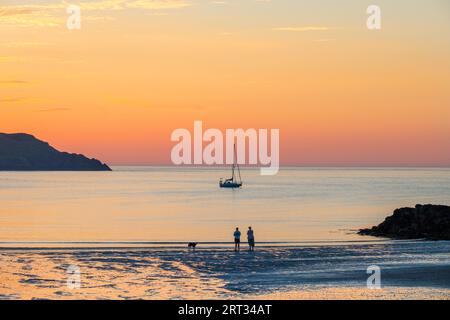 Eine Yacht vor Anker bei Sonnenuntergang an der Nordküste von Anglesey bei Cemaes in Wales Stockfoto