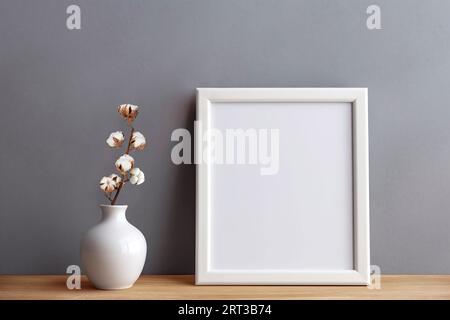 Rahmen und Plakatmotiv im Wohnzimmer mit Tonzweig in Tonvase. Skandinavisches Interieur. Stockfoto