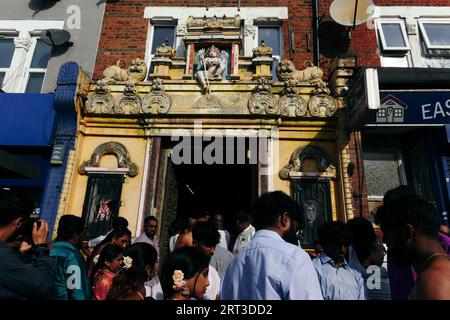 London, Großbritannien. September 2023. Tausende hinduistische Gläubige versammeln sich in Walthamstow im Osten Londons, um die jährliche Prozession des Sri Karphaha Vinayagar Temple Rathayatra zu feiern, bei der ein Wagen von Gläubigen in einem Zeichen der Einheit und des Glaubens gezogen wird. Einige Devotees entscheiden sich dafür, dass Haken durch ihren Rücken gepierct werden, die an Seilen befestigt sind, die andere Devotees halten, und ein Devotee auf der Prozession wird von ihren hinteren Haken auf eine Struktur auf einem Van gehisst, wo er für die Dauer des Tages gehängt wird. © Simon King/Alamy Live News Stockfoto