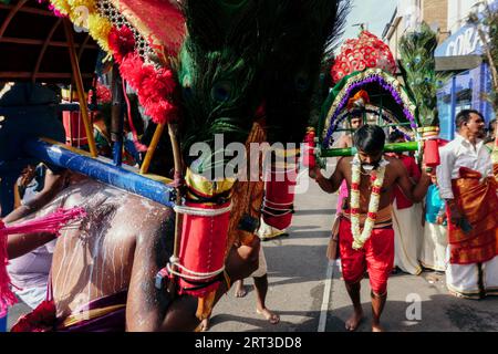 London, Großbritannien. September 2023. Tausende hinduistische Gläubige versammeln sich in Walthamstow im Osten Londons, um die jährliche Prozession des Sri Karphaha Vinayagar Temple Rathayatra zu feiern, bei der ein Wagen von Gläubigen in einem Zeichen der Einheit und des Glaubens gezogen wird. Einige Devotees entscheiden sich dafür, dass Haken durch ihren Rücken gepierct werden, die an Seilen befestigt sind, die andere Devotees halten, und ein Devotee auf der Prozession wird von ihren hinteren Haken auf eine Struktur auf einem Van gehisst, wo er für die Dauer des Tages gehängt wird. © Simon King/Alamy Live News Stockfoto