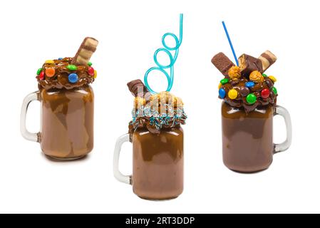 Schokoladenmilchshake mit Schlagsahne, Keksen, Waffeln, serviert in einem Glas mit Steinmauererglas. „Freak or crazy“ sweet Shake. Isoliert. Platz für Text oder Design. Stockfoto