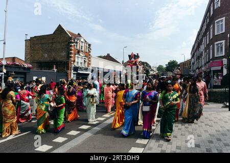 London, Großbritannien. September 2023. Tausende hinduistische Gläubige versammeln sich in Walthamstow im Osten Londons, um die jährliche Prozession des Sri Karphaha Vinayagar Temple Rathayatra zu feiern, bei der ein Wagen von Gläubigen in einem Zeichen der Einheit und des Glaubens gezogen wird. Einige Devotees entscheiden sich dafür, dass Haken durch ihren Rücken gepierct werden, die an Seilen befestigt sind, die andere Devotees halten, und ein Devotee auf der Prozession wird von ihren hinteren Haken auf eine Struktur auf einem Van gehisst, wo er für die Dauer des Tages gehängt wird. © Simon King/Alamy Live News Stockfoto