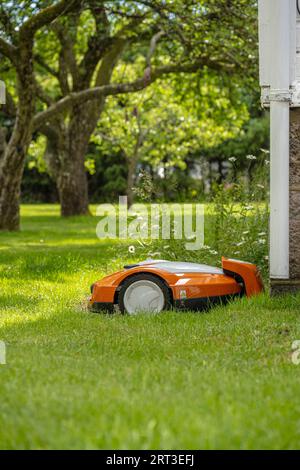 Orangefarbener und weißer Mähroboter Stockfoto