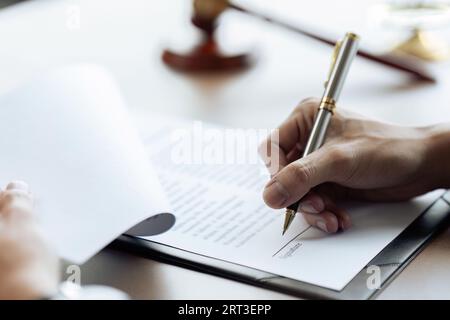 Anwälte oder Richter unterzeichnen Dokumente in Übereinstimmung mit rechtlichen und fairen Vertragsbedingungen Stockfoto