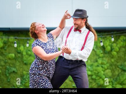 Porträt eines fröhlichen Paares, das in Vintage-Kleidung gekleidet ist und Retro-Swing-Tanz tanzt, der während der West Coast Swing-Ära in den 1920er bis 40er Jahren sehr beliebt war Sie Stockfoto