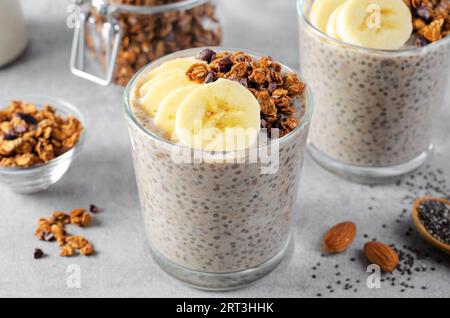 Chia Pudding mit Banana, Granola und Zimt, Bananenhafer über Nacht, gesundes Frühstück oder Snack, Parfait, vegetarische Speisen Stockfoto