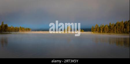 Panoramaaussicht auf die nebelige Herbstmorgendlandschaft am Isteren-See in Engerdal kommune, Norwegen, Skandinavien. Stockfoto