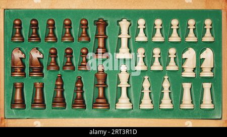 Schachstücke in einer Holzkiste hinter dem Schachbrett verstauen Stockfoto