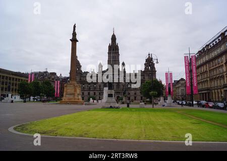 Glasgow, Schottland (UK): Ein Blick auf den George Square mit den City Chambers, Sir Walter Scott Kolumne und Robert Burns Statue Stockfoto