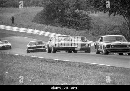 Die Autos fahren auf der Trans am 1969 in Watkins Glen Rennstrecke in New York State über die Kurve 3 bergauf Stockfoto