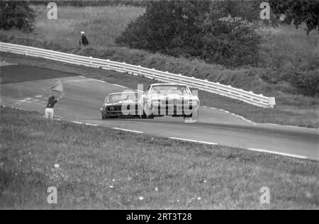 Die Autos fahren auf der Trans am 1969 in Watkins Glen Rennstrecke in New York State über die Kurve 3 bergauf Stockfoto