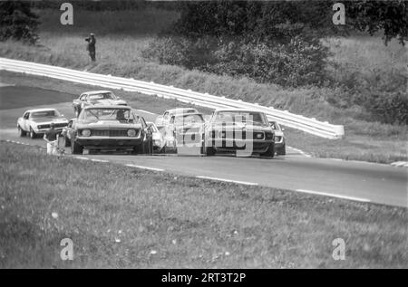 Die Autos fahren auf der Trans am 1969 in Watkins Glen Rennstrecke in New York State über die Kurve 3 bergauf Stockfoto