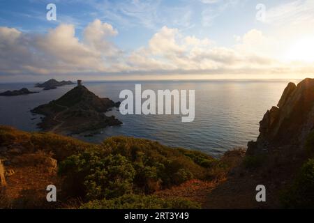 Sonnenuntergang über dem beliebten Touristenziel Torra di Parata mit genuesischem Turm und Inselgruppe Sanguinaires im Hintergrund. Stockfoto