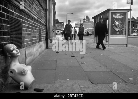 Toxteth Riot, Großbritannien 1980er Am Morgen nach den Unruhen liegt eine Schaufensterpuppe auf dem Bürgersteig, an der ein Polizist vorbeigeht. Liverpool 8 Lancashire Juli 1981 HOMER SYKES Stockfoto