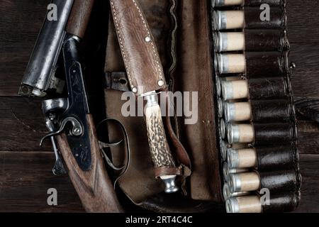 Antike 12-Gauge-Schrotflinte mit glattem Loch und Papierkästen auf Holztisch. Stockfoto