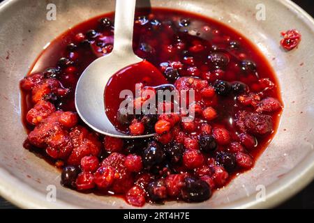 Ein gemischtes rotes Kompott aus Sommerfrüchten in einer Schüssel mit einem Servierlöffel, Teil eines Selbstbedienungsfrühstücks vom Buffet in einem Hotel. Stockfoto
