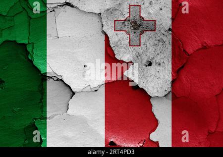Die Flaggen Italiens und Maltas sind auf gerissenen Wänden gemalt Stockfoto