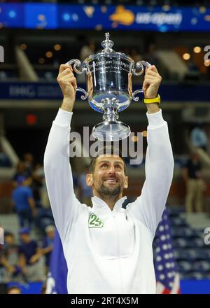 New York, USA, 10. September 2023. Der serbische Tennisspieler Novak Djokovic hält die Trophäe der US Open 2023 nach dem historischen 24. Grand Slam gewinnt am Sonntag, den 10. September 2023, im Billie Jean King National Tennis Center. © Jürgen Hasenkopf / Alamy Live News Stockfoto