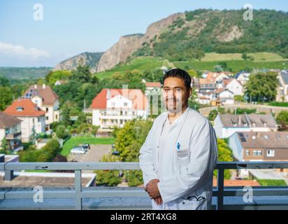 Bad Kreuznach, Deutschland. 30. August 2023. José Jiménez, Fachärztin für Geriatrie Rheinhessen-nahe, steht auf der Dachterrasse vor der Kulisse des Rotenfels, eines der Wahrzeichen dieser Region. Mit dem Programm „Specialized!“, der Bundesagentur für Arbeit, soll dem Fachkräftemangel im medizinischen Bereich entgegengewirkt werden. Die geriatrische Fachklinik Rheinhessen-nahe beschäftigt seit 2022 unter anderem einen Arzt aus Mexiko-Stadt. (An dpa 'Ärzte und Krankenschwestern aus dem Ausland, um Fachkräftemangel zu lindern') Credit: Andreas Arnold/dp/dpa/Alamy Live News Stockfoto