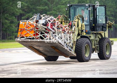 Sumter, South Carolina, USA. August 2023. US Air Force Tech. Sgt. Brandon Clemons, Leiter der Abteilung Transport der 20th Logistics Readiness Squadron Air Transport, entlädt Lieferungen, die von einer C-17 Globemaster III geliefert wurden, die dem 437th Airlift Wing von der Joint Base Charleston, S.C. während der Übung Iron Hand 23-08 am North Auxiliary Airfield, S.C., 21. August 2023 zugewiesen wurde. Die C-17 lieferten während der gesamten Übung Transport für Airmen, Ausrüstung und Treibstoff, sodass der 20th Fighter Wing seine operativen Fähigkeiten an einem abgelegenen Ort testen konnte, was die Grundlage der Agile Combat Employment IDEA INR ist Stockfoto