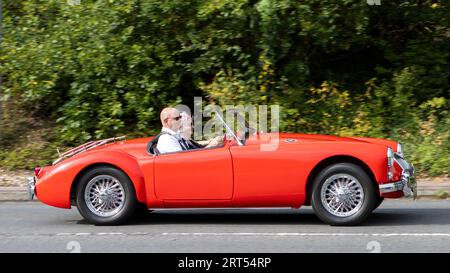 Milton Keynes, UK-Sept 10th 2023: 1955 roter MGA-Sportwagen, der auf einer englischen Straße fährt. Stockfoto