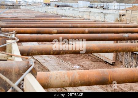 Ein riesiger Gräben-Tunnel mit Verstärkungsstrukturen aus dicken Eisenrohren und Bauten auf der Baustelle des unterirdischen Me Stockfoto