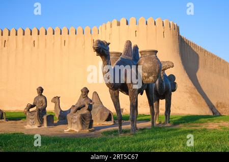 Die Skulptur zeigt eine typische Gruppe von Männerhändlern, Kamele, die für die Nacht ruhen. An der bronzenen Silk Road Caravan Skulptur vor dem alten f Stockfoto