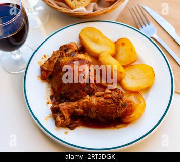 Gebackenes Hühnchen mit Tomatensoße und knusprigen Bratkartoffeln Stockfoto