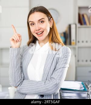 Geschäftsfrau, die im Büro steht und zeigt Stockfoto